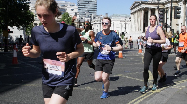 A picture of me (Luc Shelton) in between two other participants, running around the corner on the final kilometre of the ASICS London 10K. There is a guy to my right taking a picture of himself!