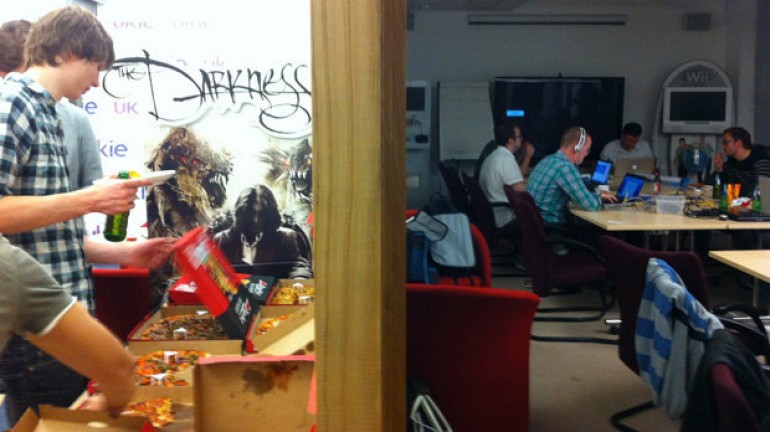 Some of the team hard of work while others grab pizza.